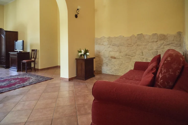 Zimmer mit Steinwand und rotem Sofa
